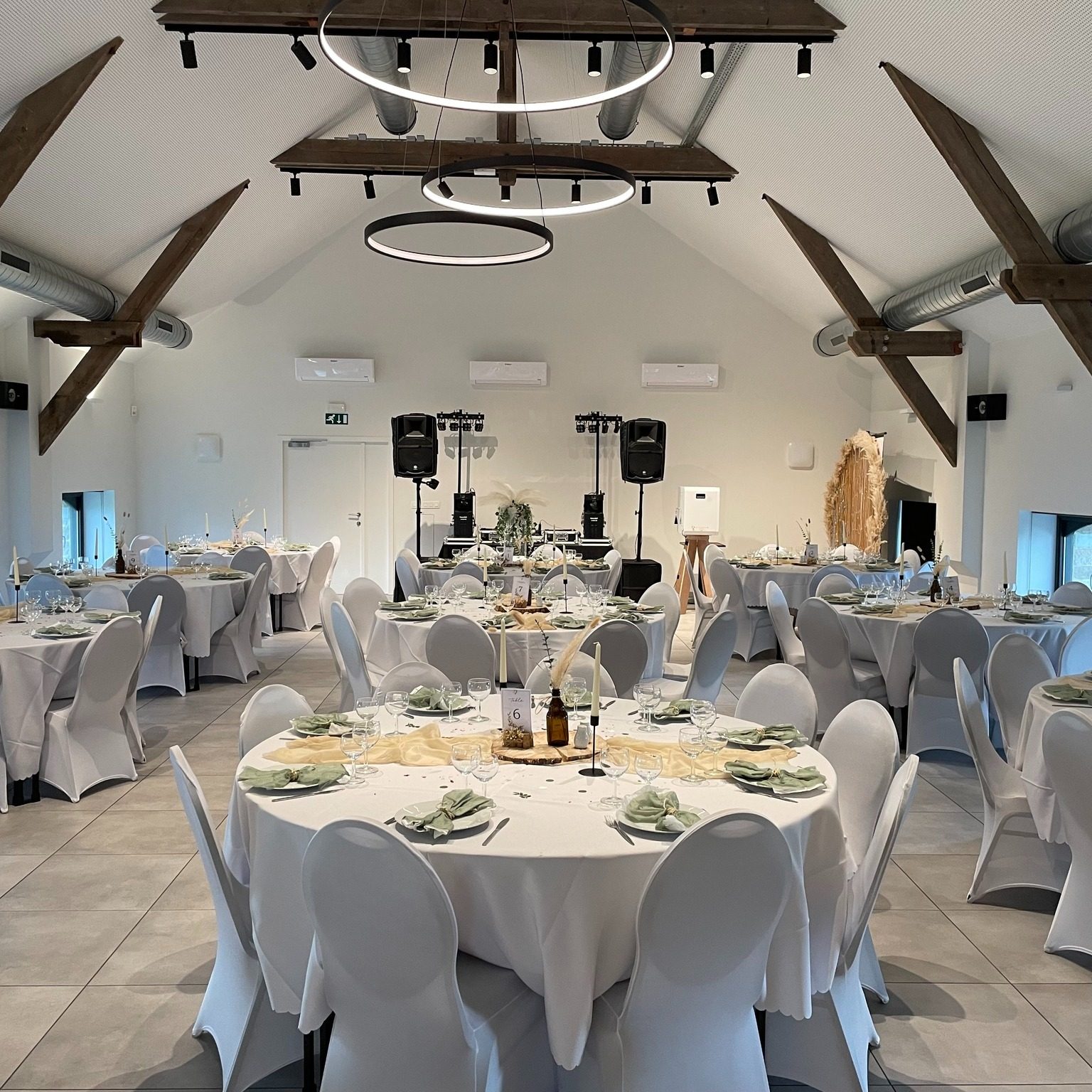 Salle dressée avec tables rondes et chaises blanches